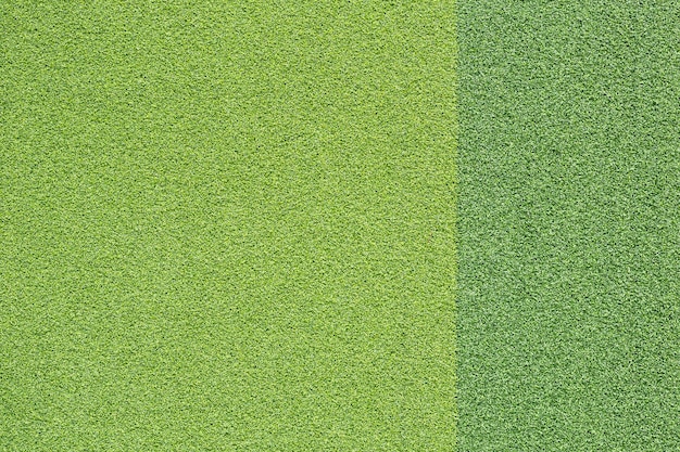 Pattern of bright and dark artificial green grass for texture and background