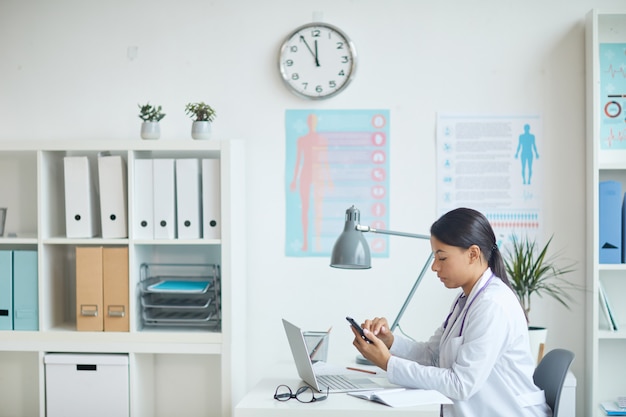 Photo pediatrician sitting at her office