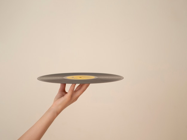 Person holding up vinyl disk with copy-space