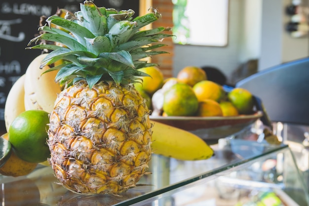 Pineapple with many fruits on top of beverage bar in cafe