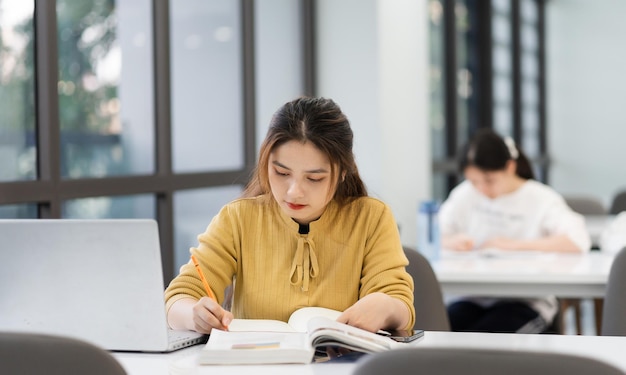 Photo portrait of asian female student studying at university library