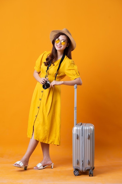 Photo portrait of beautiful asian girl wearing yellow dress on orange background