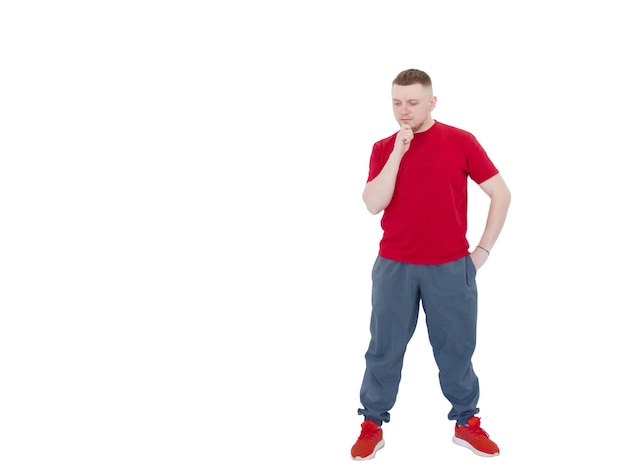 Portrait of a beautiful young guy in sports clothes thinking and holding his head with his hand the guy is thinking about something on an isolated white background