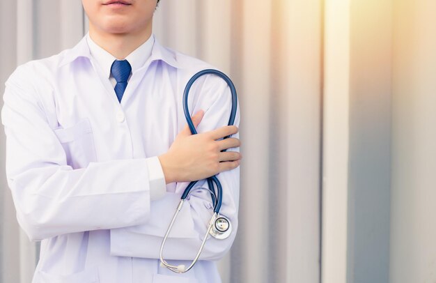 Foto stetoscopio della stretta del braccio attraversato sorridente dell'uomo di medico del ritratto