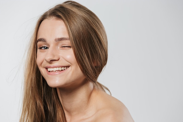 portrait of gorgeous young blonde half-naked woman with long hair winking isolated on white