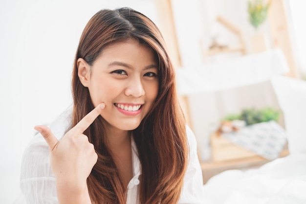 Photo 自宅のベッドで笑顔の若い女性の肖像画