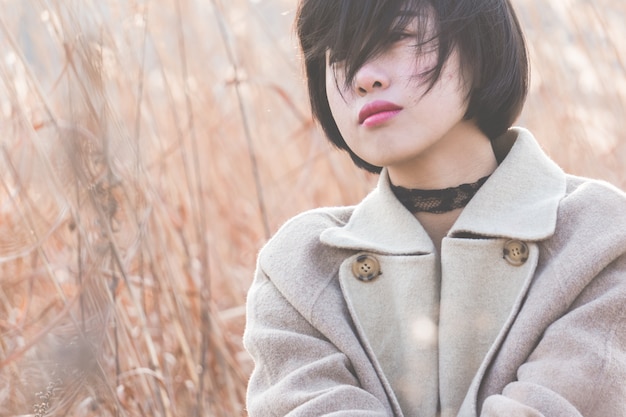 portrait of style woman sitting amidst reed field