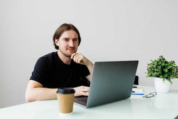 Portrait of young man sitting at his desk in the office