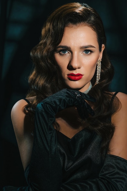 Portrait of young woman in Hollywood retro noir style A beautiful brunette girl with a hairstyle and makeup with jewelry in classic vintage look