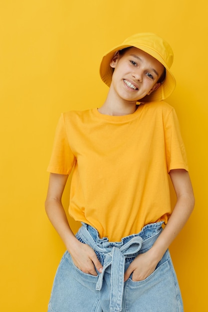 Foto portret van een jonge vrouw die tegen een gele achtergrond staat