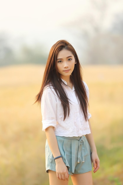 Foto portret van een mooie jonge vrouw die op het veld staat