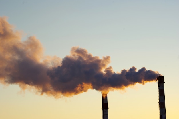 Power plant with smoke under sky