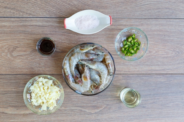 Preparation before cooking stir fried shrimp with chili, garlic and salt on wood table. top view or flat lay.