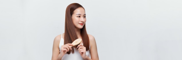 Photo pretty asian woman is combing her hair isolated on the white background panorama