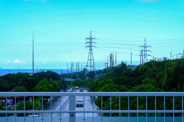 Photo railing and electricity pylons in city against blue sky