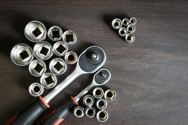 Ratchet socket wrench lying on wooden background