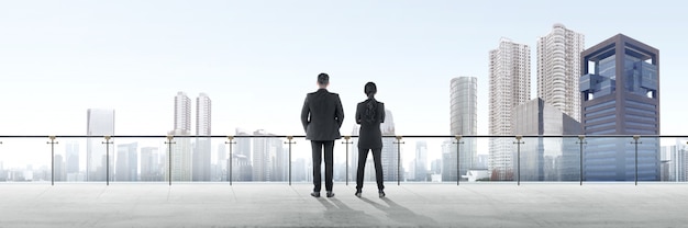 Rear view of two asian business people standing on modern terrace and looking at view