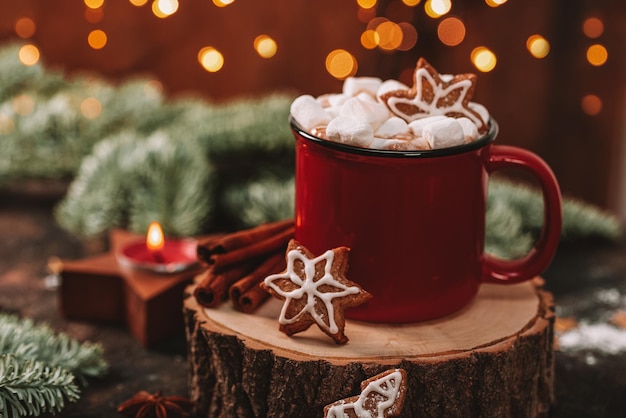 A red mug of cocoa with marshmallows and christmas cookies in a new years setting cozy christmas