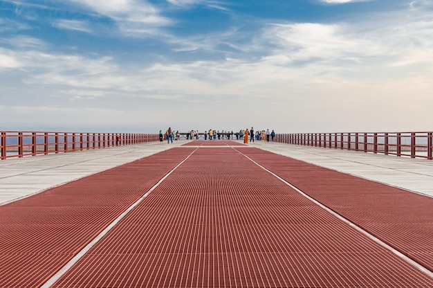 Photo a red walkway with a cloudy sky in the background