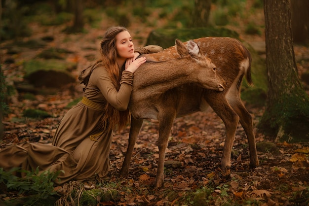 Redhead girl with deer in a long dress