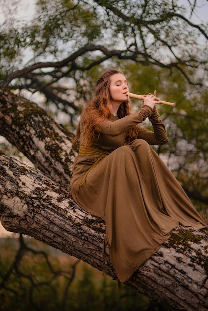 Redhead woman in green dress walking in fantasy fairy tale forest