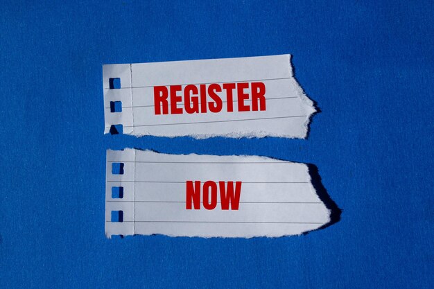 Register now message written on ripped torn paper pieces with blue background Conceptual register now symbol Copy space