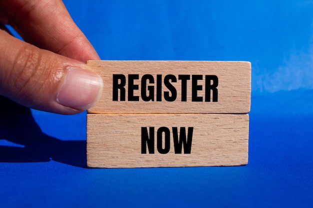 Photo register now message written on wooden blocks with blue background conceptual register now symbol copy space