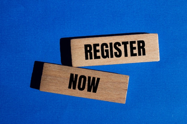 Photo register now words written on wooden blocks with blue background conceptual register now symbol copy space