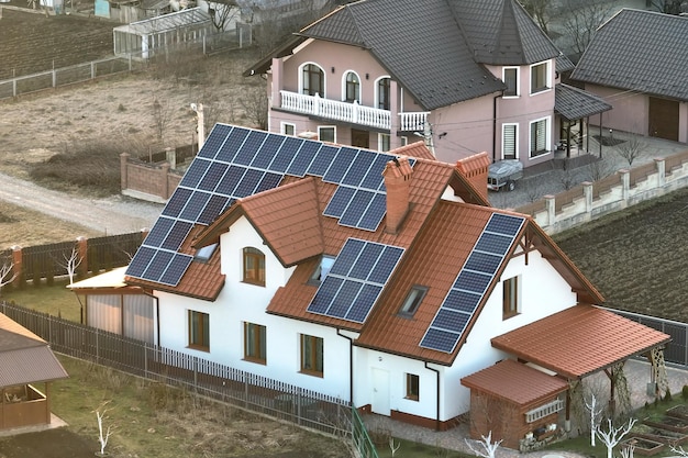 Residential house with rooftop covered with solar photovoltaic panels for producing of clean ecological electrical energy in suburban rural area Concept of autonomous home