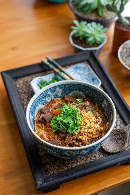 Rice noodles with spicy pork sauce on black table