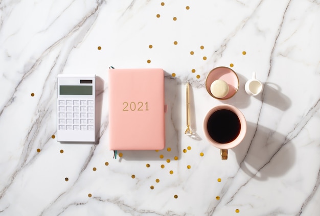 Foto roze koraalkleurige agenda voor het jaar 2021 met rekenmachine