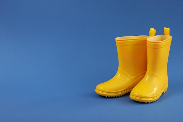 Rubber boots on blue background space for text