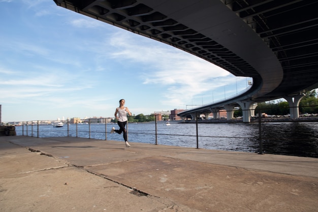 Running on the waterfront of the city at sunset