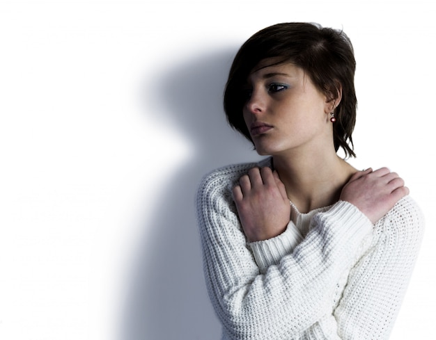 Sad pretty brunette thinking with arms crossed