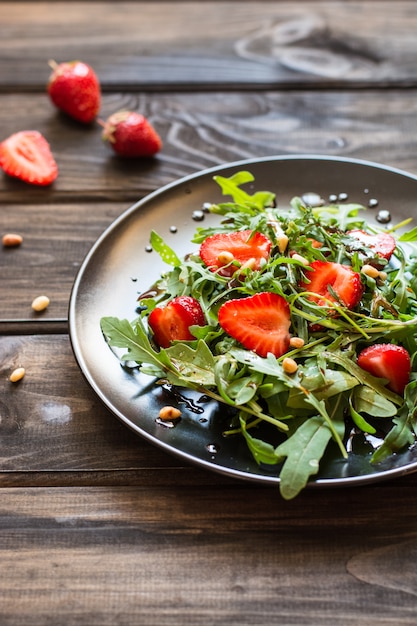 salade met rucola, strawbery, balsamico-saus, pijnboompitten. Vegetarisch eten. Vitaminevoedsel, d