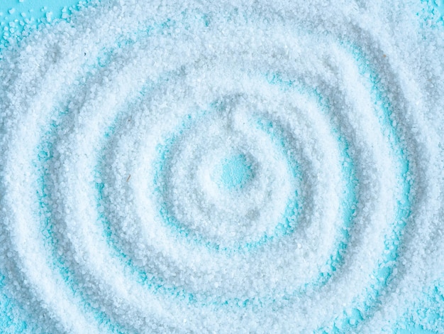 Salt is scattered on a blue in the shape of a circle