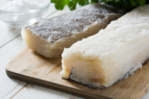 Salted dried cod on white wooden table Typical Easter food