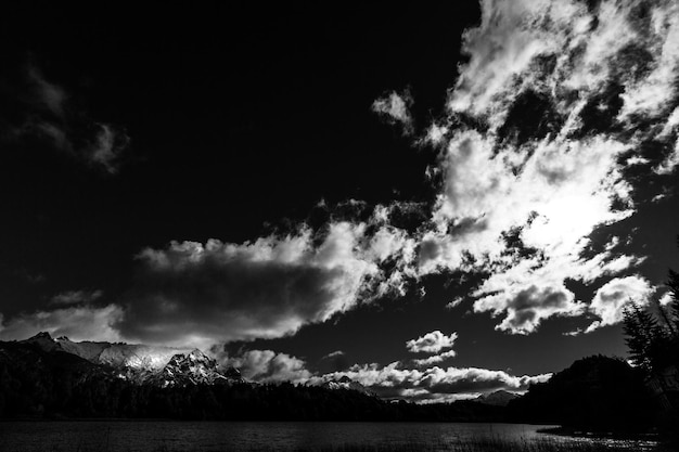 Photo scenic view of lake by silhouette mountains against sky