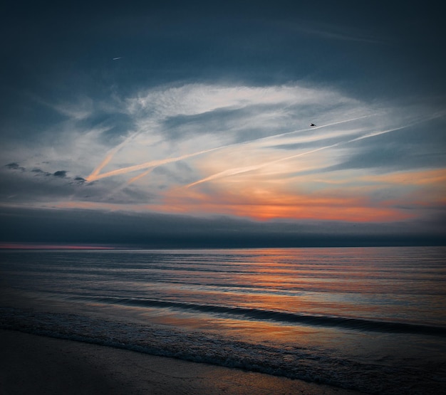 Photo scenic view of sea against sky at sunset