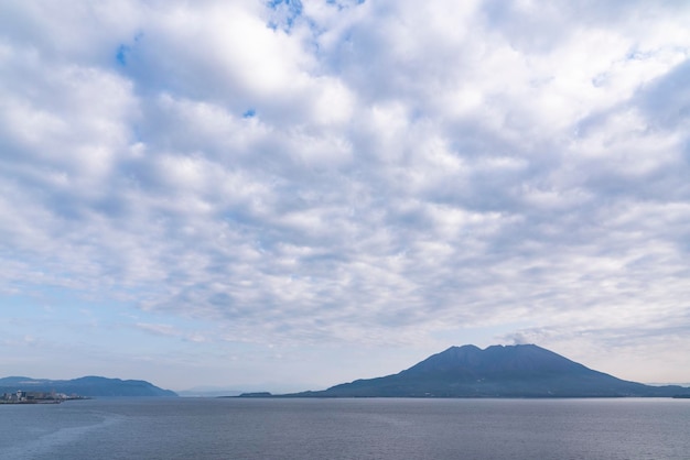 Photo scenic view of sea by mountain against sky