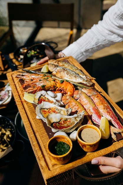 Foto piatto di pesce e frutti di mare con gamberetti grigliati, ostriche di pesce, disegno del menu, pubblicità alimentare, progetti culinari