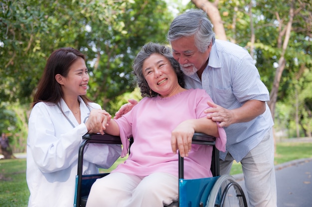 Senior man caring for disabled wife in his wheelchair.