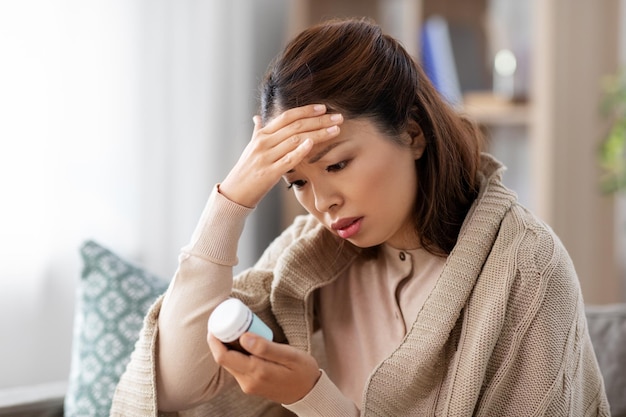 Photo sick asian woman with painkiller medicine at home