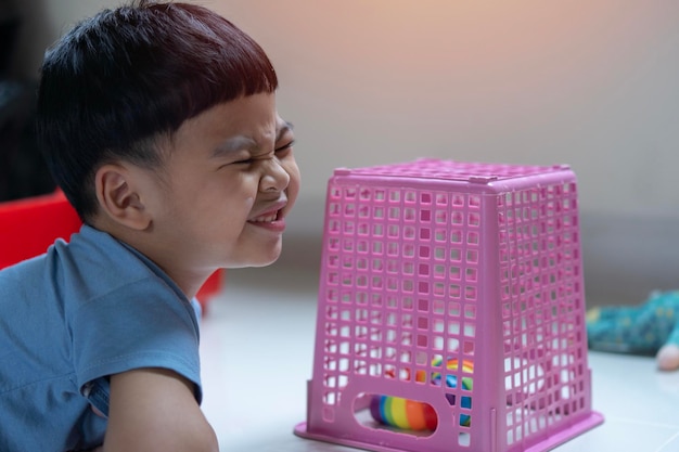 Side view portrait of creative little dorable Asian boy having fun during playtime at home