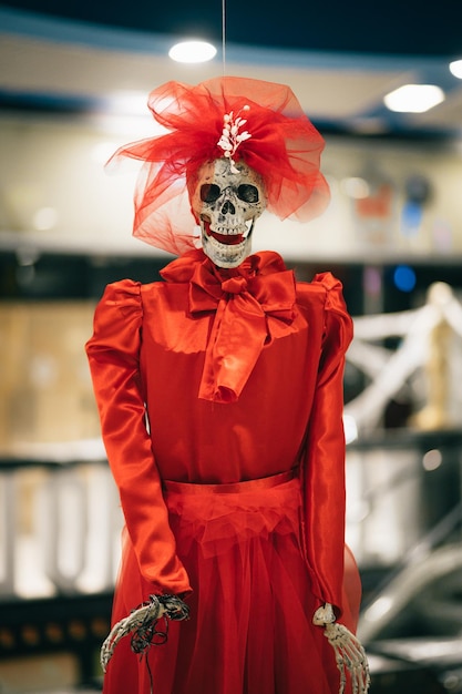 Skeleton of a woman in a red dress indoors looking at the camera