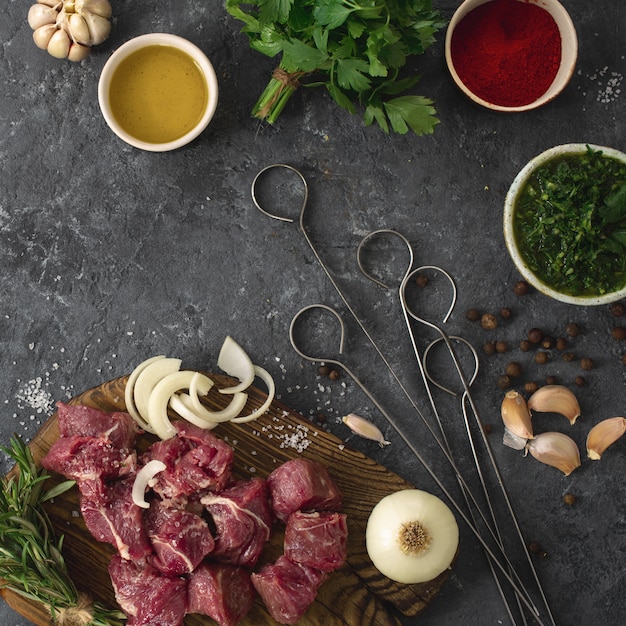 Sliced beef fillet with vegetable. kitchen table with Ñuts meat and veggies on dark table top view. Ingredients cooking meat