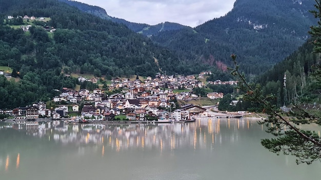 A small town in the mountains with a lake in the foreground