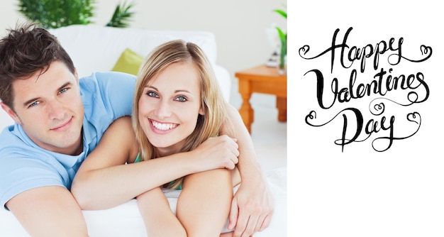 Smiling beatiful couple sitting on a sofa against happy valentines day