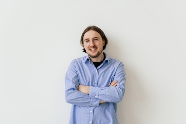 Smiling handsome man standing with crossed arms isolated on gray background