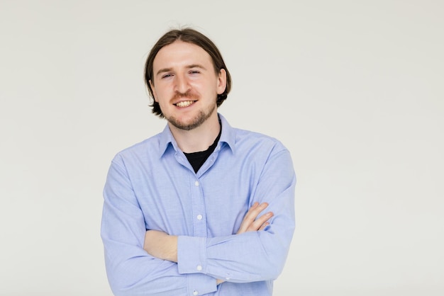 Smiling handsome man standing with crossed arms isolated on gray background